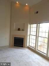 6212 Westchester Park Dr Unit J, College Park, MD 20740 - unfurnished living room featuring a fireplace and carpet