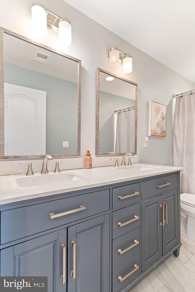 42026 Zircon Dr, Aldie, VA 20105 - bathroom with double vanity, toilet, and marble look tiles