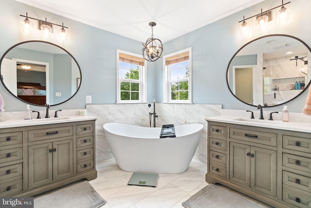 42026 Zircon Dr, Aldie, VA 20105 - bathroom with tile walls, a chandelier, two vanities, a freestanding tub, and a shower stall