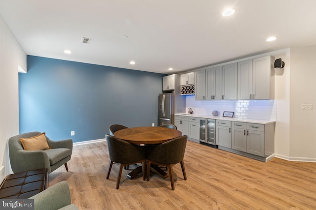 42026 Zircon Dr, Aldie, VA 20105 - dining space featuring wet bar, wine cooler, light wood-style flooring, recessed lighting, and baseboards
