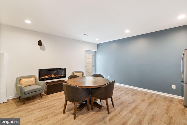 42026 Zircon Dr, Aldie, VA 20105 - dining space featuring a glass covered fireplace, light wood-type flooring, recessed lighting, and baseboards