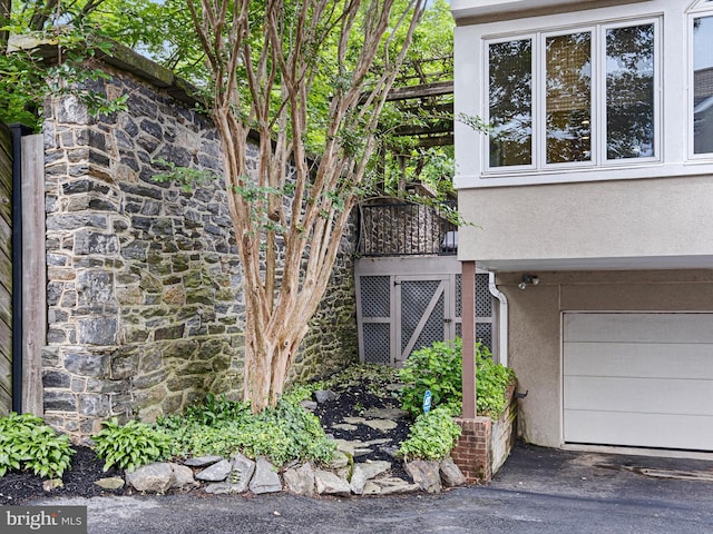 2000 N Bancroft Pkwy, Wilmington, DE 19806 - view of property exterior with stucco siding, stone siding, a garage, and driveway