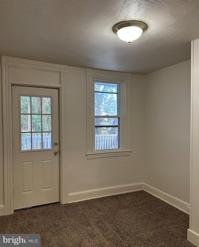 33 New Dorwart St, Lancaster, PA 17603 - doorway to outside featuring dark colored carpet, plenty of natural light, a textured ceiling, and baseboards