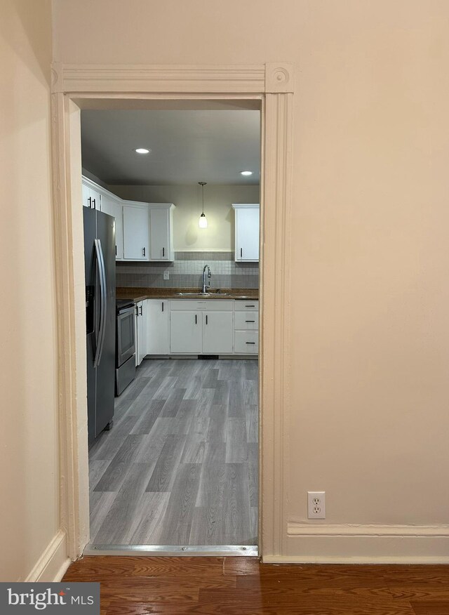 33 New Dorwart St, Lancaster, PA 17603 - kitchen featuring stainless steel appliances, a sink, wood finished floors, white cabinets, and dark countertops