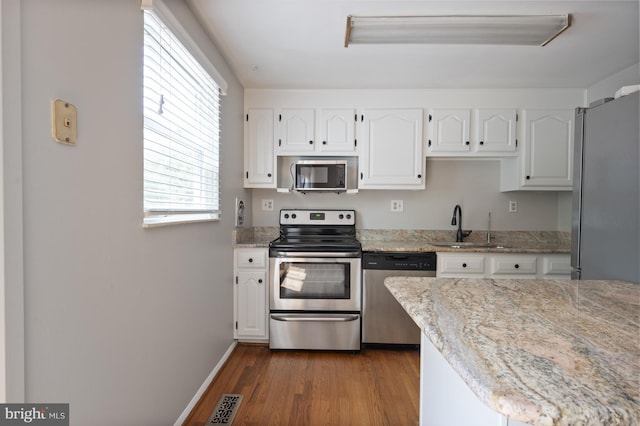 1100 Clarke St, Herndon, VA 20170 - kitchen featuring appliances with stainless steel finishes, white cabinetry, wood finished floors, and a sink