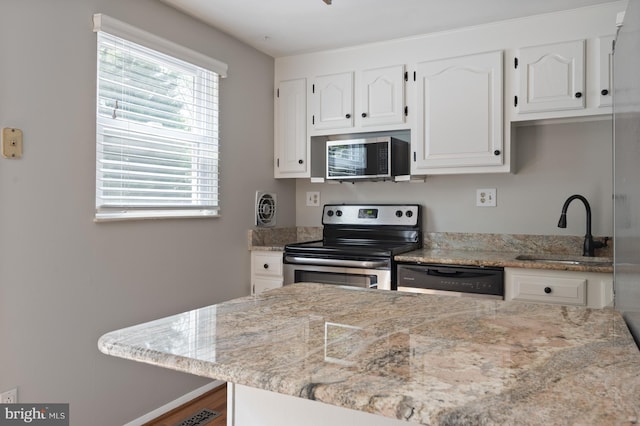 1100 Clarke St, Herndon, VA 20170 - kitchen featuring stainless steel appliances, a sink, white cabinets, and light stone counters