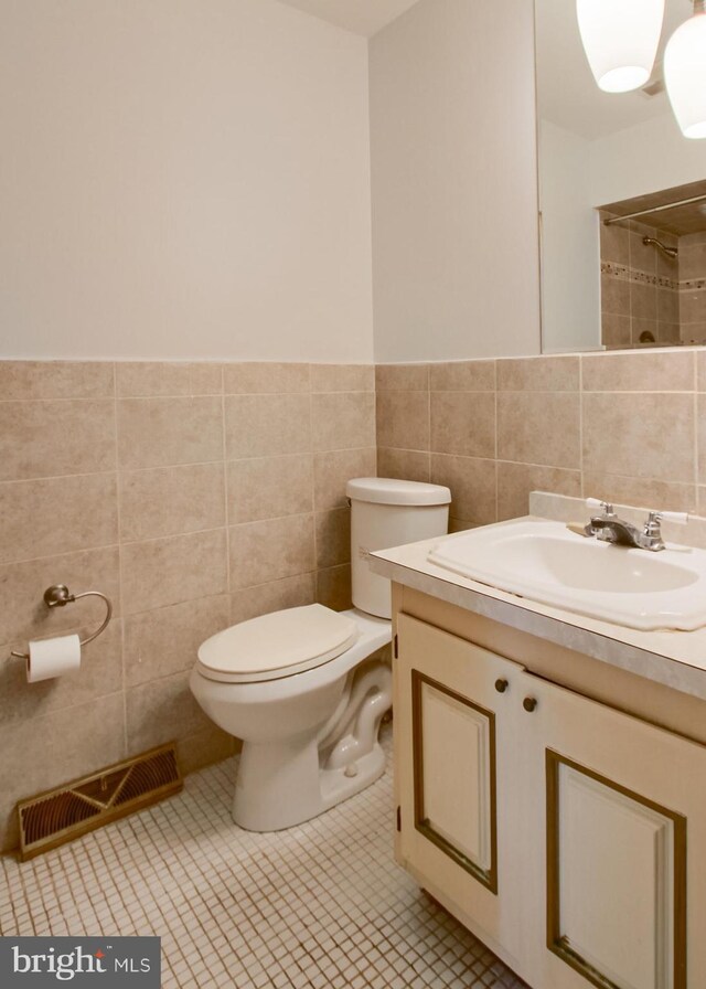 3900 Mark Ave, Harrisburg, PA 17110 - bathroom featuring tile walls, toilet, vanity, a shower, and wainscoting