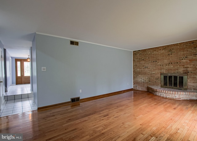3900 Mark Ave, Harrisburg, PA 17110 - unfurnished living room with hardwood / wood-style flooring, baseboards, a fireplace, and crown molding