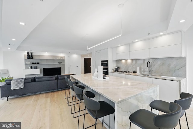 1111 19th St N Unit 2108, Arlington, VA 22209 - kitchen with a sink, modern cabinets, white cabinets, light wood-style floors, and recessed lighting