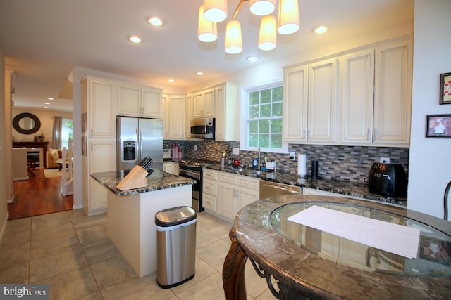 1300 Park Garden Ln, Reston, VA 20194 - kitchen with appliances with stainless steel finishes, tasteful backsplash, light tile patterned floors, a kitchen island, and a sink
