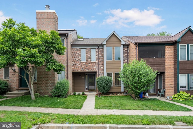 9441 Clocktower Ln, Columbia, MD 21046 - view of front of house featuring a front yard, a chimney, and brick siding