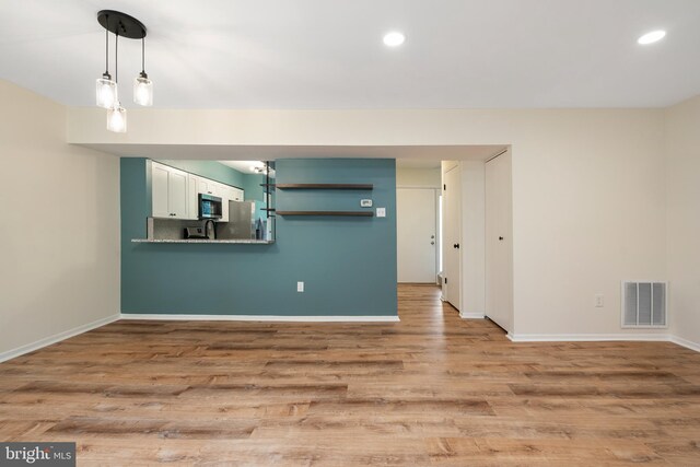 9441 Clocktower Ln, Columbia, MD 21046 - unfurnished living room featuring baseboards, light wood-style floors, recessed lighting, and a sink