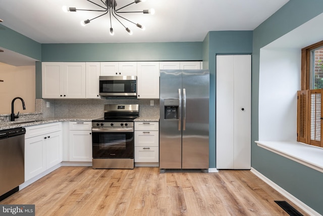 9441 Clocktower Ln, Columbia, MD 21046 - kitchen featuring appliances with stainless steel finishes, a sink, white cabinetry, and tasteful backsplash
