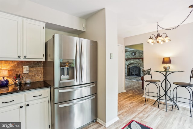 922 Pheasant Run Dr, Gaithersburg, MD 20878 - kitchen with stainless steel fridge, dark countertops, backsplash, white cabinets, and light wood-type flooring