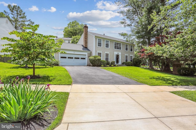 922 Pheasant Run Dr, Gaithersburg, MD 20878 - colonial home with asphalt driveway, a front yard, an attached garage, and a chimney