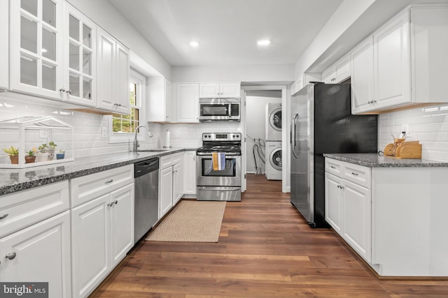 12419 Melling Ln, Bowie, MD 20715 - kitchen featuring stainless steel appliances, stacked washer / drying machine, a sink, white cabinetry, and glass insert cabinets