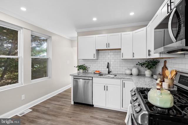 1402 W Old Cold Spring Ln, Baltimore, MD 21209 - kitchen with appliances with stainless steel finishes, a sink, crown molding, light stone counters, and tasteful backsplash