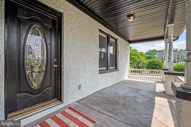 1402 W Old Cold Spring Ln, Baltimore, MD 21209 - view of exterior entry with covered porch and stucco siding