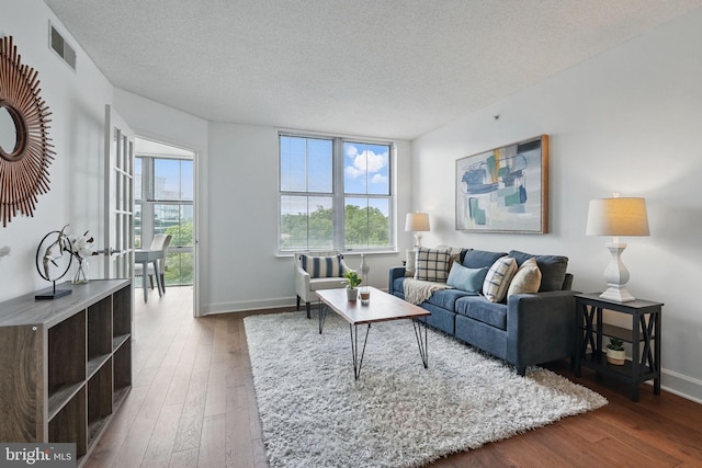 11800 Sunset Hills Rd Unit 717, Reston, VA 20190 - living room with wood-type flooring, a textured ceiling, healthy amount of natural light, and baseboards