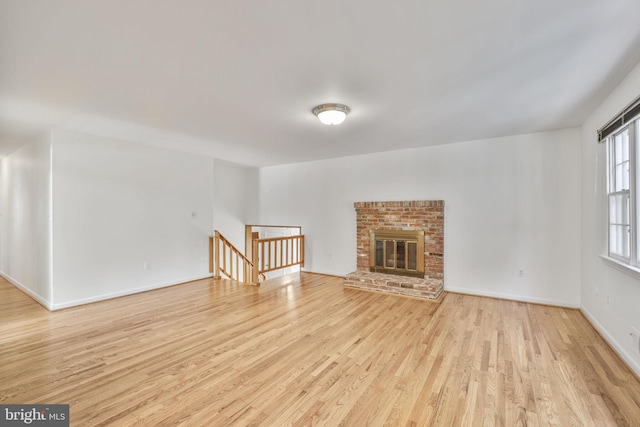 12403 Sir Lancelot Dr, Glenn Dale, MD 20769 - unfurnished living room with light wood-type flooring, baseboards, and a brick fireplace