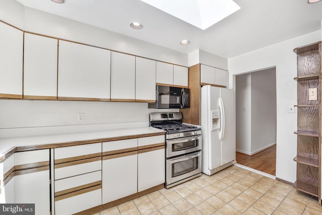 12403 Sir Lancelot Dr, Glenn Dale, MD 20769 - kitchen with range with two ovens, white fridge with ice dispenser, black microwave, light countertops, and white cabinets