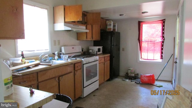 8804 48th Ave, College Park, MD 20740 - kitchen with white appliances, a sink, light countertops, under cabinet range hood, and brown cabinets