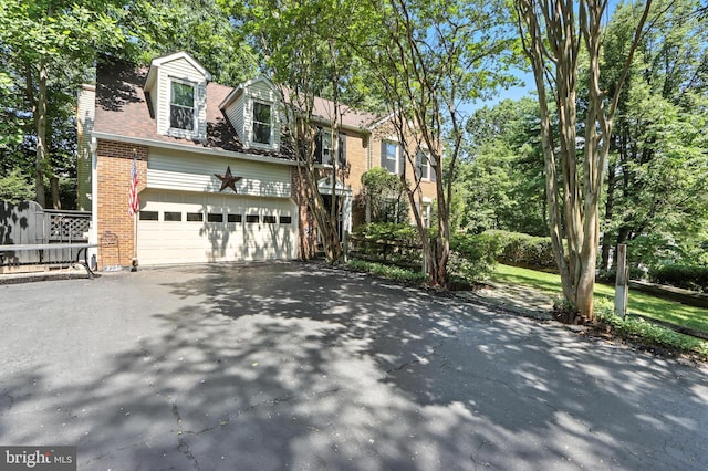 8225 Bubbling Spg, Laurel, MD 20723 - view of front of house with asphalt driveway, brick siding, and an attached garage