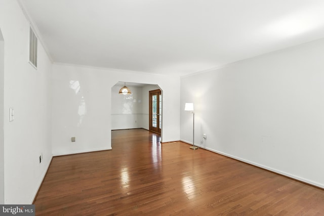 8225 Bubbling Spg, Laurel, MD 20723 - spare room featuring arched walkways, wood finished floors, and ornamental molding