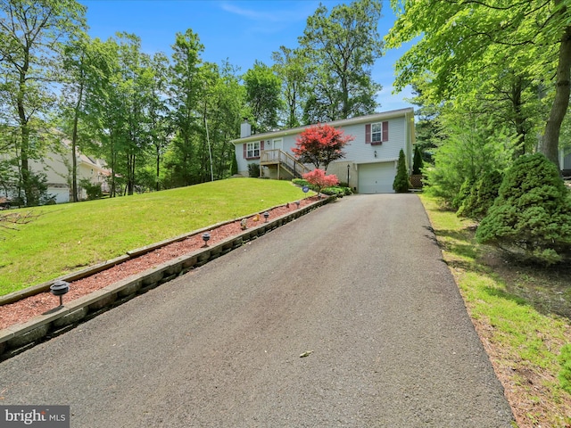 95 Comanche Dr, Auburn, PA 17922 - view of front of house with driveway, an attached garage, a front lawn, and a chimney