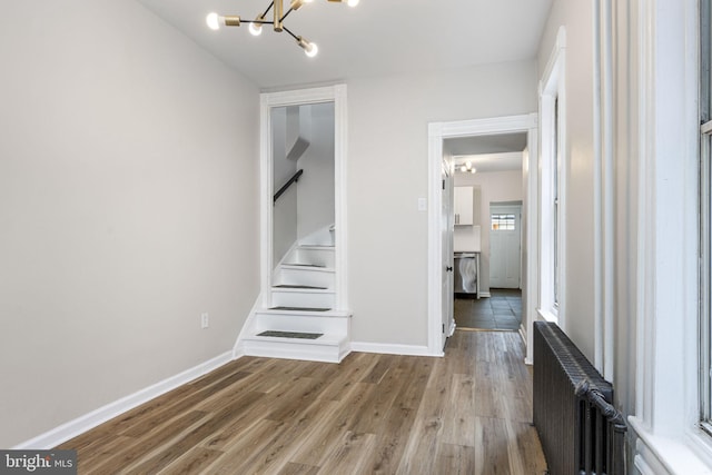 551 Gordon St, Reading, PA 19601 - corridor with radiator, a chandelier, stairway, wood finished floors, and baseboards