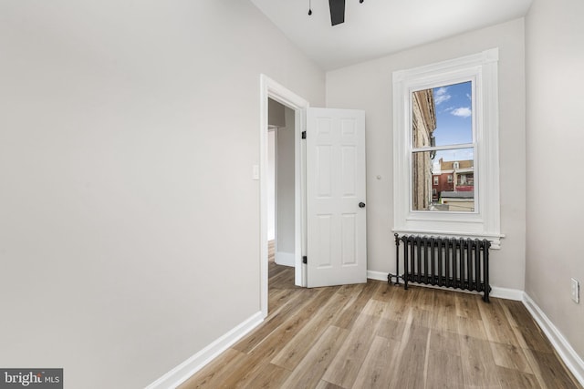 551 Gordon St, Reading, PA 19601 - unfurnished room featuring radiator heating unit, light wood-style flooring, baseboards, and a ceiling fan