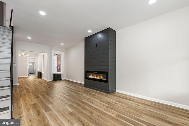 551 Gordon St, Reading, PA 19601 - unfurnished living room with light wood finished floors, radiator, a large fireplace, baseboards, and recessed lighting