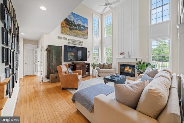3 Graham Ct, Middletown, DE 19709 - living area featuring a towering ceiling, a glass covered fireplace, plenty of natural light, light wood-type flooring, and recessed lighting