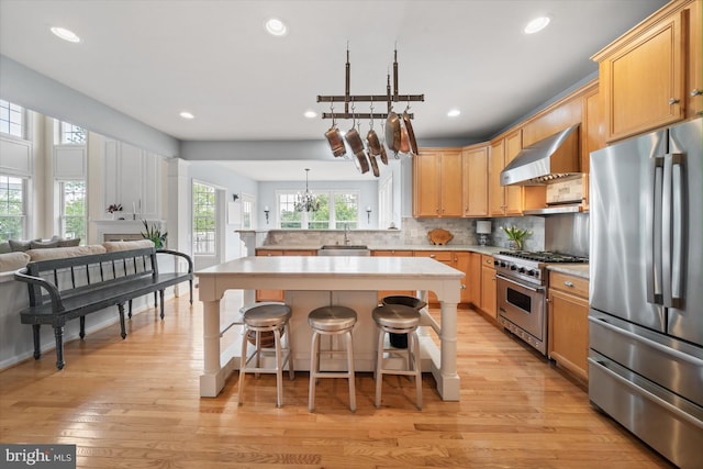 3 Graham Ct, Middletown, DE 19709 - kitchen featuring appliances with stainless steel finishes, wall chimney exhaust hood, a sink, open floor plan, and light countertops