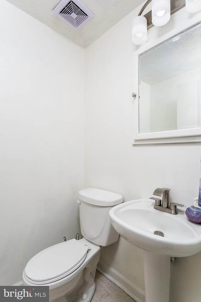 10263 Wayover Way, Columbia, MD 21046 - half bath featuring toilet, baseboards, tile patterned floors, a textured ceiling, and a sink