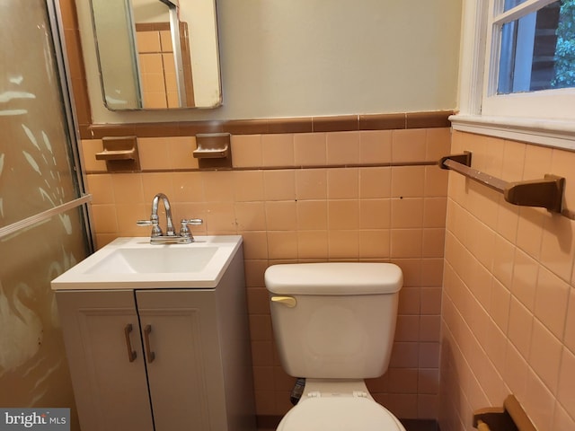 5900 Arbroath Dr, Clinton, MD 20735 - bathroom featuring vanity, toilet, tile walls, and wainscoting
