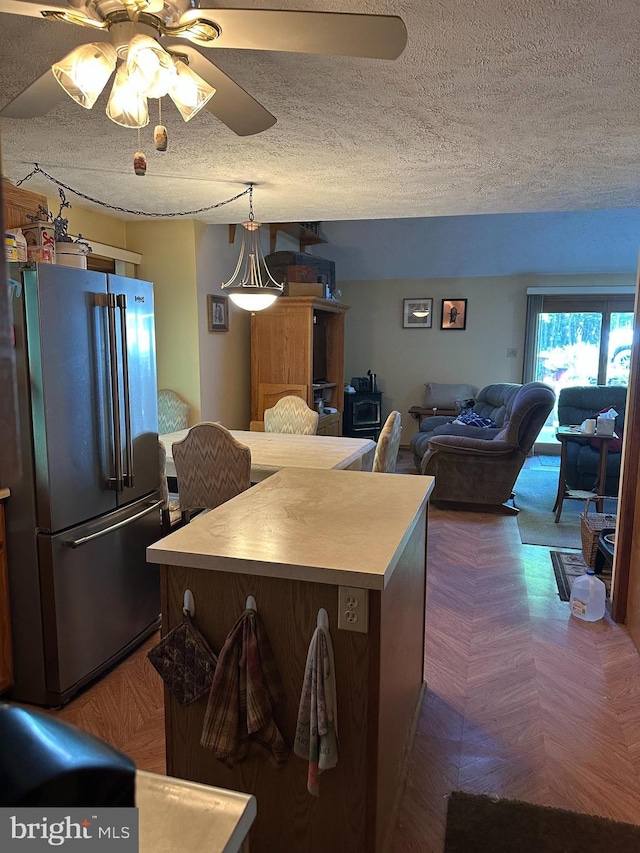 202 Tepee Dr, Pocono Lake, PA 18347 - kitchen with freestanding refrigerator, a textured ceiling, a ceiling fan, light countertops, and a kitchen island