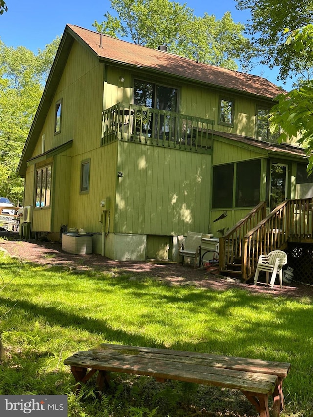 202 Tepee Dr, Pocono Lake, PA 18347 - rear view of house with a lawn, roof with shingles, and a sunroom