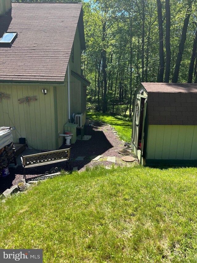 202 Tepee Dr, Pocono Lake, PA 18347 - view of home's exterior with a storage unit, a lawn, and a shingled roof