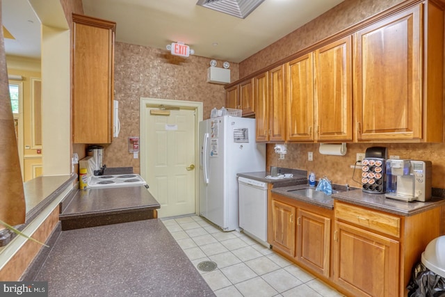 29865 Hillary Ave, Easton, MD 21601 - kitchen with white appliances, a sink, dark countertops, light tile patterned floors, and brown cabinets