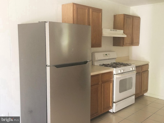 7602 Old Linton Hall Rd, Gainesville, VA 20155 - kitchen with white range with gas stovetop, freestanding refrigerator, under cabinet range hood, and brown cabinetry