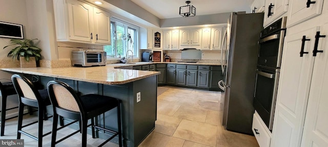 4 E Spring Oak Cir, Media, PA 19063 - kitchen with appliances with stainless steel finishes, gray cabinets, a peninsula, a breakfast bar, and a sink