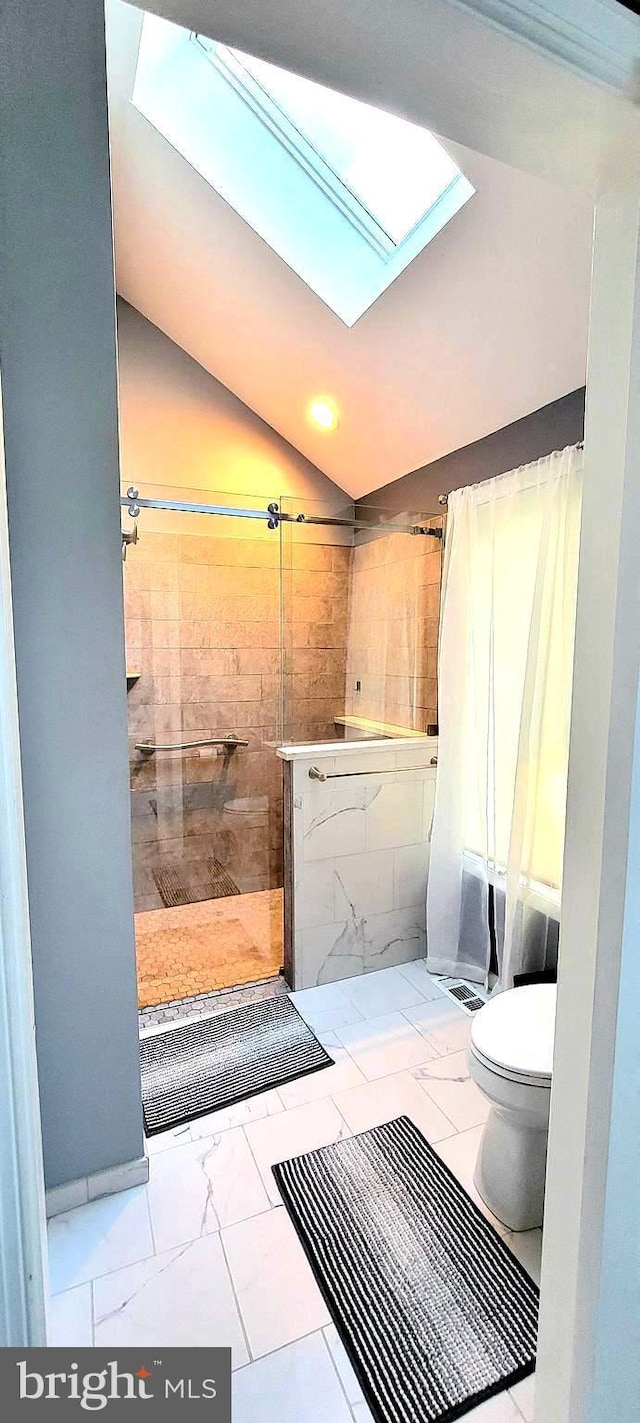 4 E Spring Oak Cir, Media, PA 19063 - bathroom with toilet, marble look tile flooring, a tile shower, a skylight, and vaulted ceiling