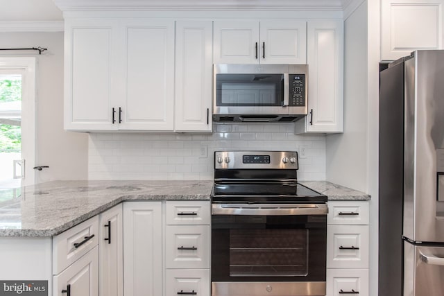 351 Doone Rd, Fairless Hills, PA 19030 - kitchen with appliances with stainless steel finishes, crown molding, tasteful backsplash, white cabinetry, and light stone counters