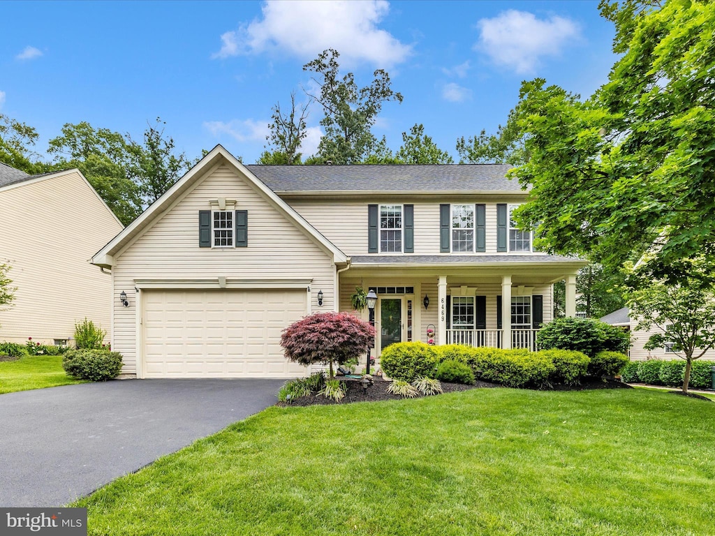 6469 Saddlebrook Ln, Frederick, MD 21701 - view of front of house with asphalt driveway, covered porch, a front lawn, and a garage