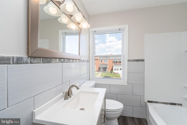 1738 Stokesley Rd, Baltimore, MD 21222 - full bath with tile walls, a bath, toilet, vanity, and a wainscoted wall