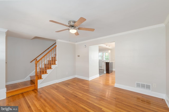 1738 Stokesley Rd, Baltimore, MD 21222 - empty room featuring wood finished floors, a ceiling fan, stairs, crown molding, and baseboards