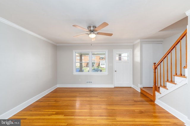 1738 Stokesley Rd, Baltimore, MD 21222 - entrance foyer featuring light wood finished floors, ceiling fan, stairs, baseboards, and crown molding