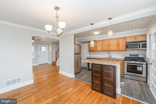 1738 Stokesley Rd, Baltimore, MD 21222 - kitchen with appliances with stainless steel finishes, decorative backsplash, a sink, a chandelier, and light wood-style flooring