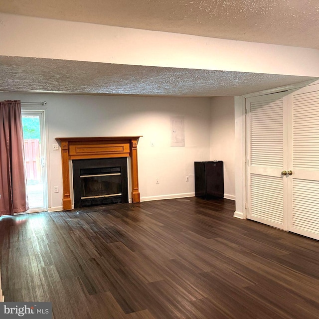 11289 Kessler Pl, Manassas, VA 20109 - unfurnished living room featuring dark wood-type flooring, baseboards, a glass covered fireplace, and a textured ceiling